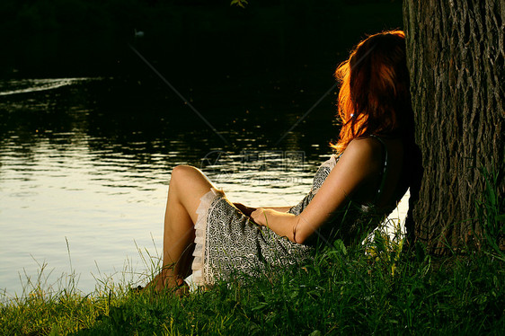 女孩坐在森林河岸上的女孩女士国家树木成人草地娱乐银行女性农村乡村图片