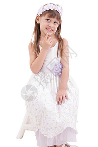 小女孩穿白色衣服 穿着白色礼服 坐在白面包上摆着椅子图片