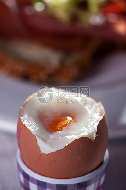 开放鸡蛋的特写蛋壳杯子黄色食物玻璃盘子桌子蛋黄火腿面包图片