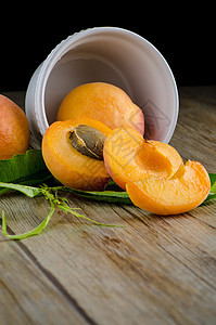 木桌上的杏子甜点维生素桌子叶子木板黄色种子水果植物宏观图片