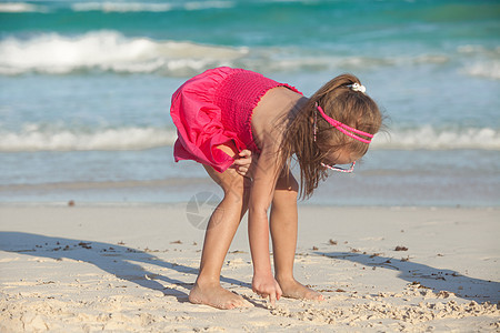 可爱的小女孩画在热带海滩上的白沙滩上图片