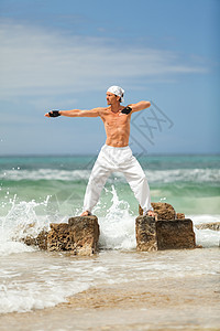 在沙滩夏天做静脉瑜伽冥想的 健康人平衡放松石头海滩活力蓝色身体天空男性姿势图片