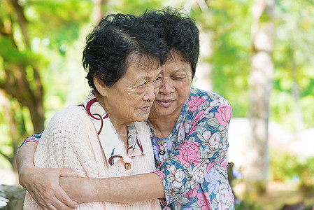 亚洲成熟的成年妇女拥抱和安慰她哭泣的老妈妈图片