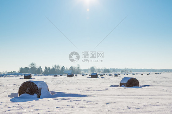 在雪雪中铺下干草的巴勒斯稻草天空房子全景蓝色季节收成暴风雪小麦收割机图片