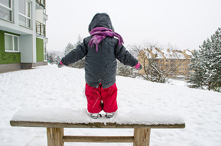 长着红裤子的小孩 站在木板凳雪上图片