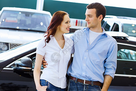 在汽车沙龙的年轻幸福情侣女性销售量白色男人经销商成人店铺顾客夫妻运输图片
