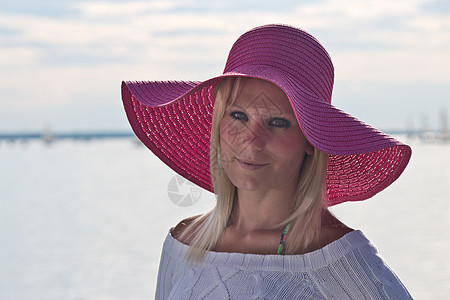 戴着粉红太阳帽子的年轻女人图片