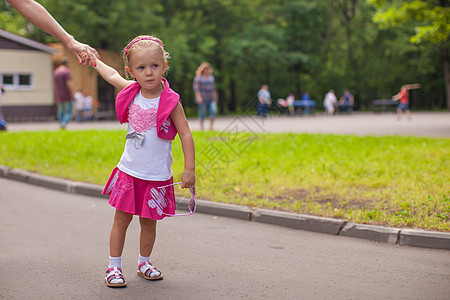 可爱的小女孩走在户外 在公园玩乐图片