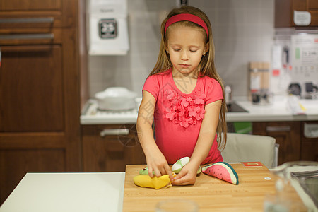 在厨房里玩水果和蔬菜的可爱小女孩帮手桌子孩子健康饮食女孩幸福衣服乐趣时间婴儿图片