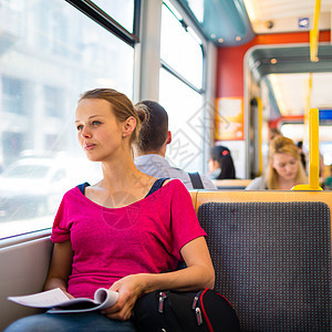坐在街车火车道上的漂亮年轻女子公共汽车女孩城市旅行女士女性乘客服务乐趣控制器图片