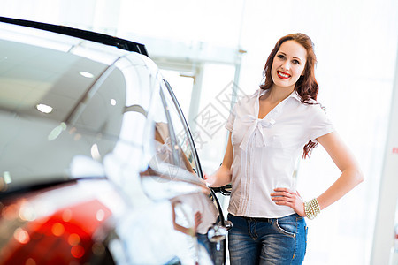站在汽车旁边的年轻妇女兜帽男人车库推销员夫妻交易成人发动机女性协议图片