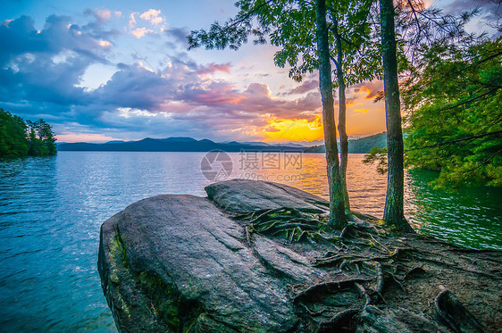 环绕湖面的风景公园生态骑手太阳外表反射树木远景丘陵旅行图片