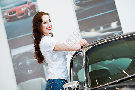 站在汽车旁边的年轻妇女机械引擎夫妻驾驶零售推销员服务女士蓝色兜帽图片
