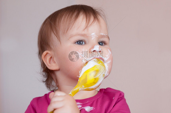 女孩用勺子吃饭 享受她最爱的食物图片