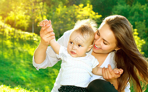 美丽的母亲和婴儿户外童年微笑女性公园乐趣女士妈妈孩子快乐家庭图片
