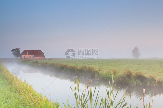 清晨雾中河边的农舍图片
