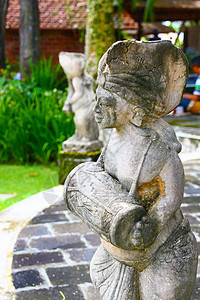 巴厘岛石雕像舞蹈家雕刻火山岩苔藓石头音乐家背景图片