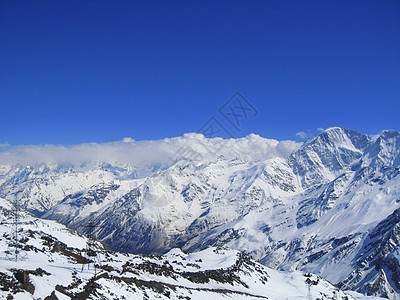 雪下和清空下的高加索山脉悬崖顶峰山脉运动白色爬坡滑雪蓝色季节石头图片