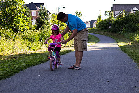 儿童学习与父亲一起骑自行车帮助男性女孩青年娱乐孩子乐趣运动闲暇踏板图片