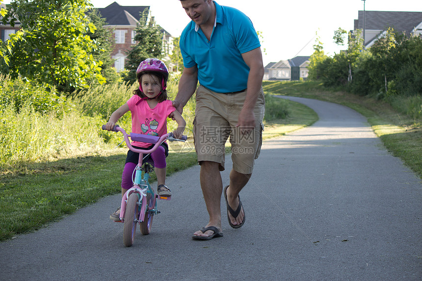 儿童学习与父亲一起骑自行车帮助运动轮子男性女孩公园孩子家庭童年爸爸图片