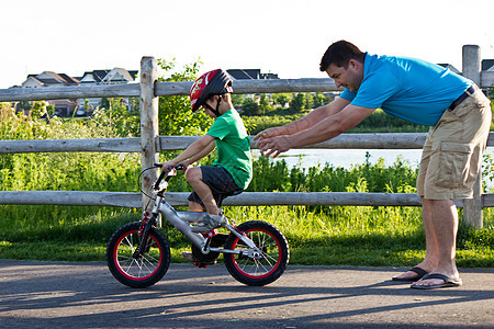 儿童学习与父亲一起骑自行车爸爸青年男性娱乐运动男生家庭两个人孩子踏板图片