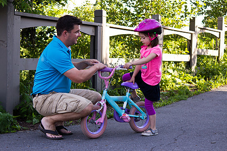 儿童学习与父亲一起骑自行车公园青年娱乐两个人运动踏板乐趣帮助女孩闲暇图片
