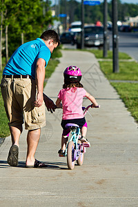 儿童学习与父亲一起骑自行车轮子家庭童年娱乐青年爸爸闲暇运动踏板两个人图片