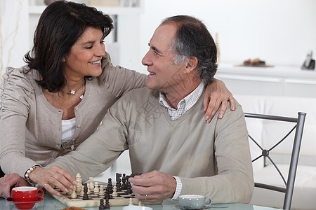 已婚夫妇在家里下象棋图片