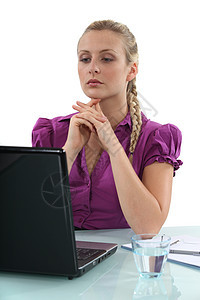妇女用水杯和笔记本电脑坐在桌上图片