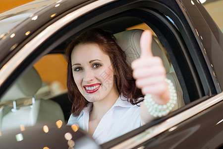 坐在车里的年轻女人 举起拇指欢乐商务快乐人士学习者女孩驾驶座位乐趣运输图片