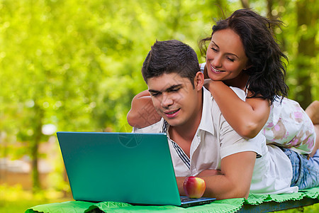 使用膝上型电脑的男女女性夫妻青年幸福友谊森林说谎异性亲热笔记本图片