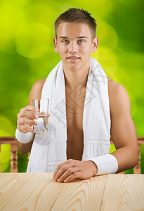 一个人拿着杯水毛巾手臂蓝色运动扶手背景桌子运动装器皿男性图片