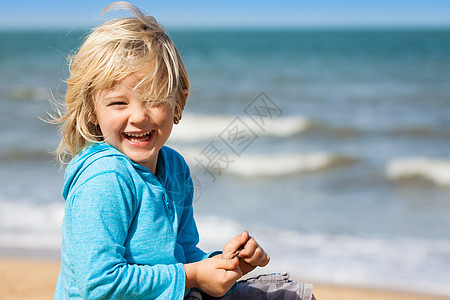 海滩上可爱的笑笑男孩图片