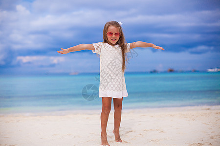 美丽的小女孩在异国海滩上张开双臂支撑乐趣童年情调女儿女性热带婴儿自由孩子图片