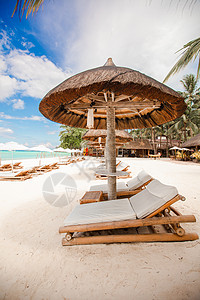 拥有雨伞和沙椅的热带空沙滩平地天堂景色海岸线旅行海景休息室椅子情调异国晴天蓝色天蓝色图片