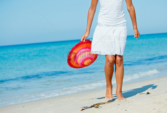 在海滩上散步假期女性闲暇帽子晴天皮肤赤脚场景日光浴海洋图片