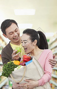 杂货店的男子喂食妇女苹果图片