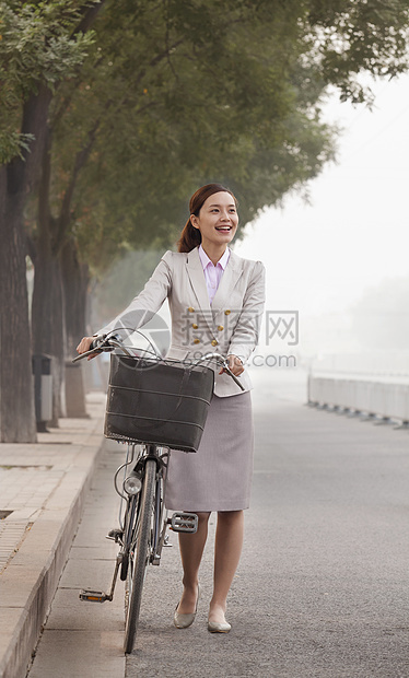 青年商业女商务人士与自行车搭乘的汽车 中国北京商务快乐衣冠幸福城市生活街道通勤者长发运动前景图片