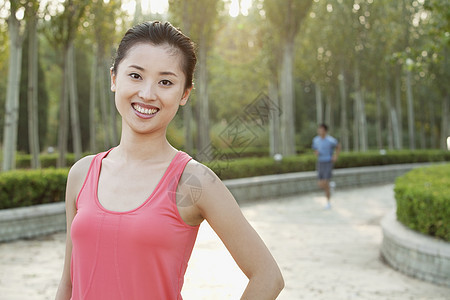 在中国北京公园穿运动服的年轻女青年女子公园跑步女性享受长发收腰生活方式露齿快乐头发图片