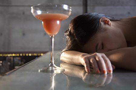 年轻妇女在酒吧柜台昏倒图片