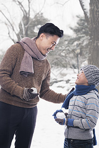 父亲和儿子带着雪球低温幸福服装棕色保暖短发摄影休闲家庭两个人图片