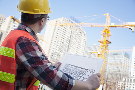 建筑设计师在建筑工地的户外建筑蓝图衬衫进步外观头饰眼镜胡须纽扣安全帽承包商起重机图片