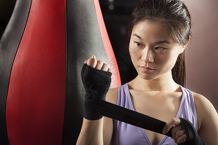 年轻自信的女性拳击手在健身房的手腕包装图片