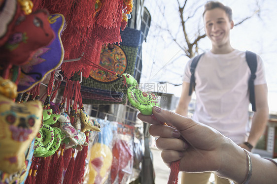 年轻夫妇在看纪念品两个人游客女性旅行摄影文化背光闲暇水平购物图片