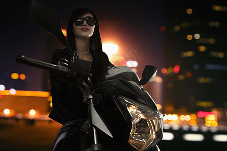 北京夜间戴墨镜坐在摩托车上的漂亮年轻女子图片