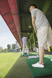 年轻人在高尔夫球场挥棒打高尔夫球图片
