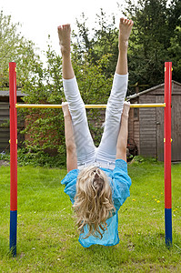 运动青年女子锻炼女孩幸福单杠女性闲暇乐趣体操金发高标准图片