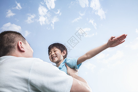 父亲抚育儿子视图天空乐趣两个人起重城市双臂飞行休闲公园图片