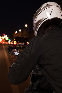 年轻人在晚上骑摩托车穿过北京街上 后视线下仰望图片