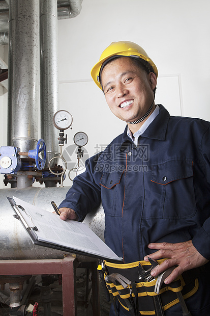 中国北京煤气厂石油管道设备检查剪贴板的笑笑工人肖像照片 中国北京图片